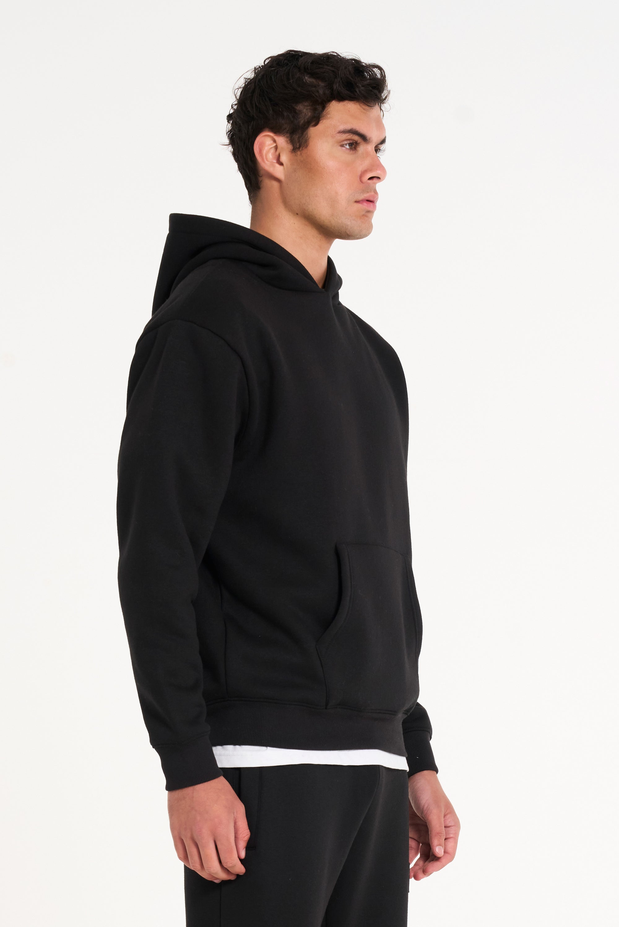 Close up shot of model facing to the right wearing full black tracksuit