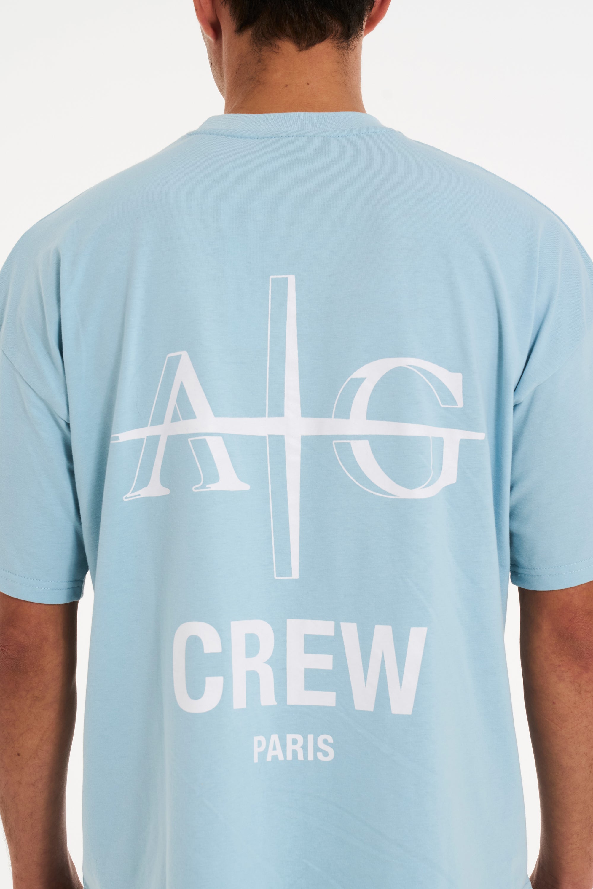 Close up backshot of sky blue T-shirt with Avant Garde logo on the back