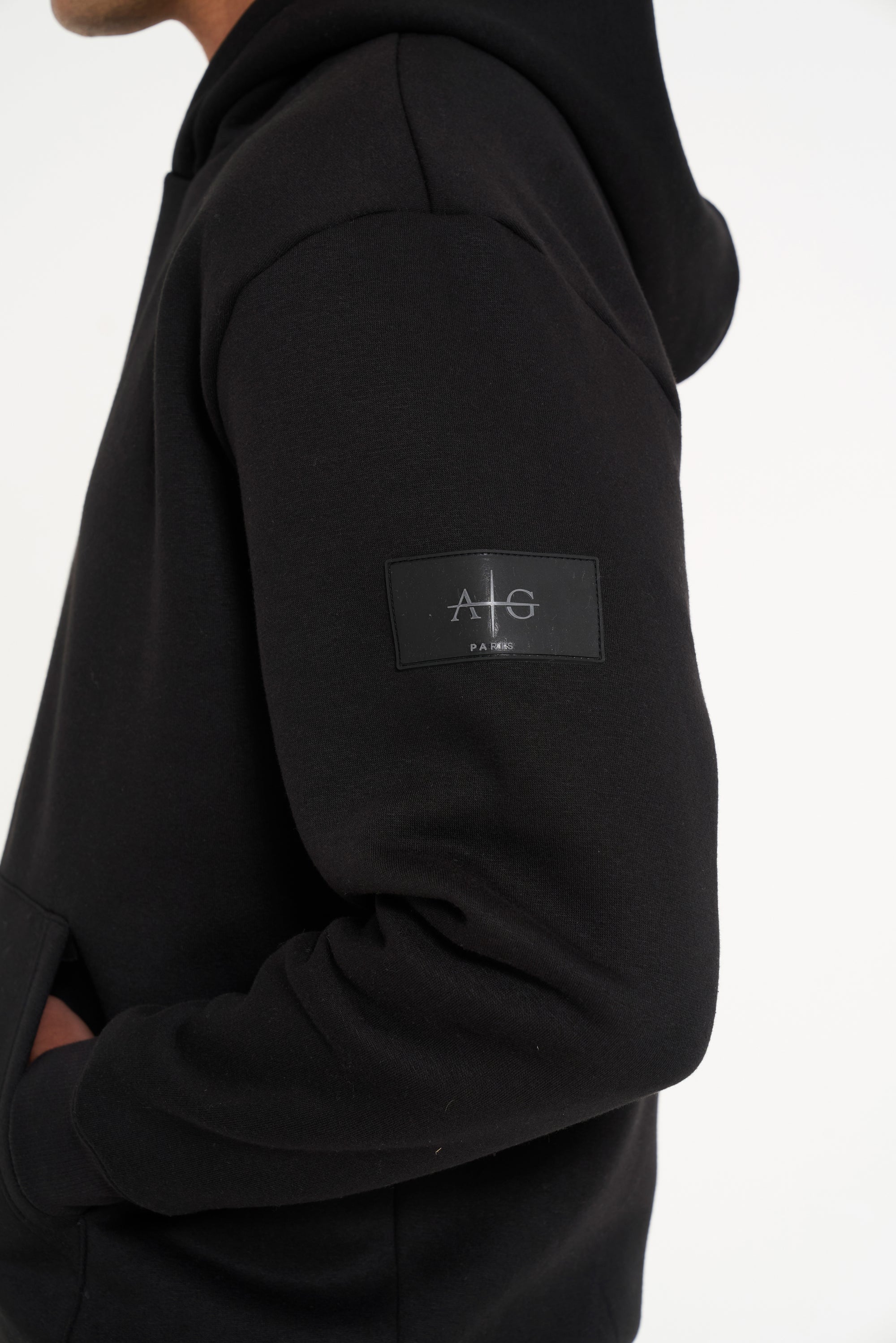 Close up shot of Avant Garde logo on the arm of black tracksuit top