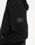 Close up shot of Avant Garde logo on the arm of black tracksuit top