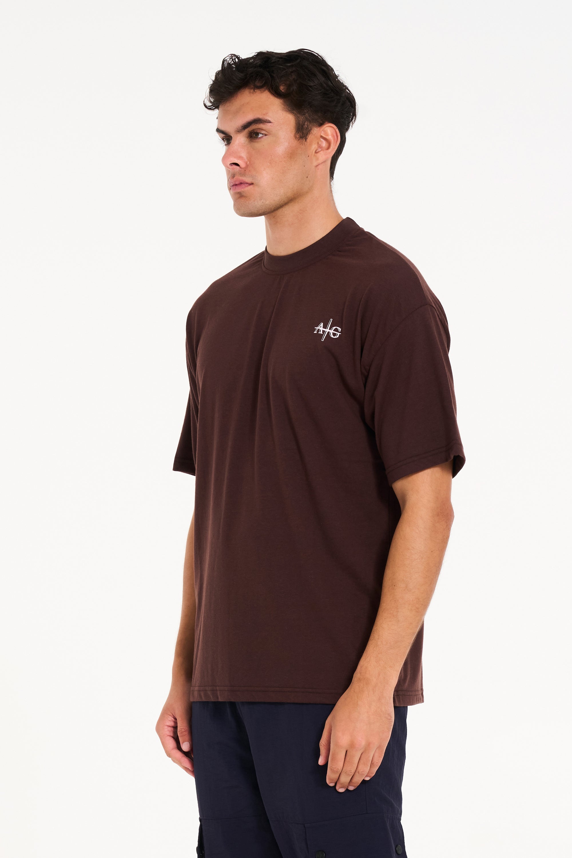 Model facing to the left wearing brown crew neck T-shirt