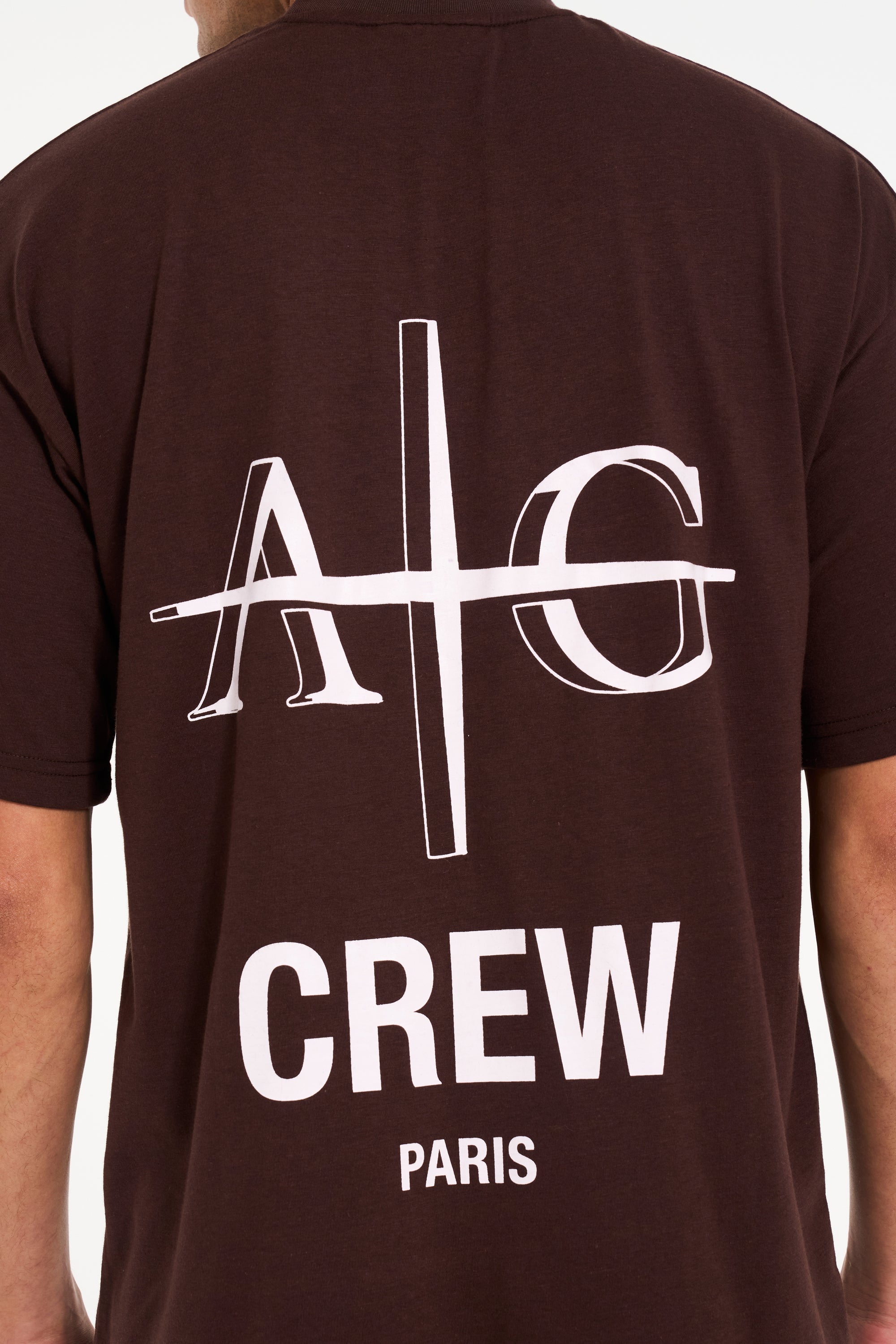 Close up backshot of brown crew neck T-shirt with Avant Garde logo on the back