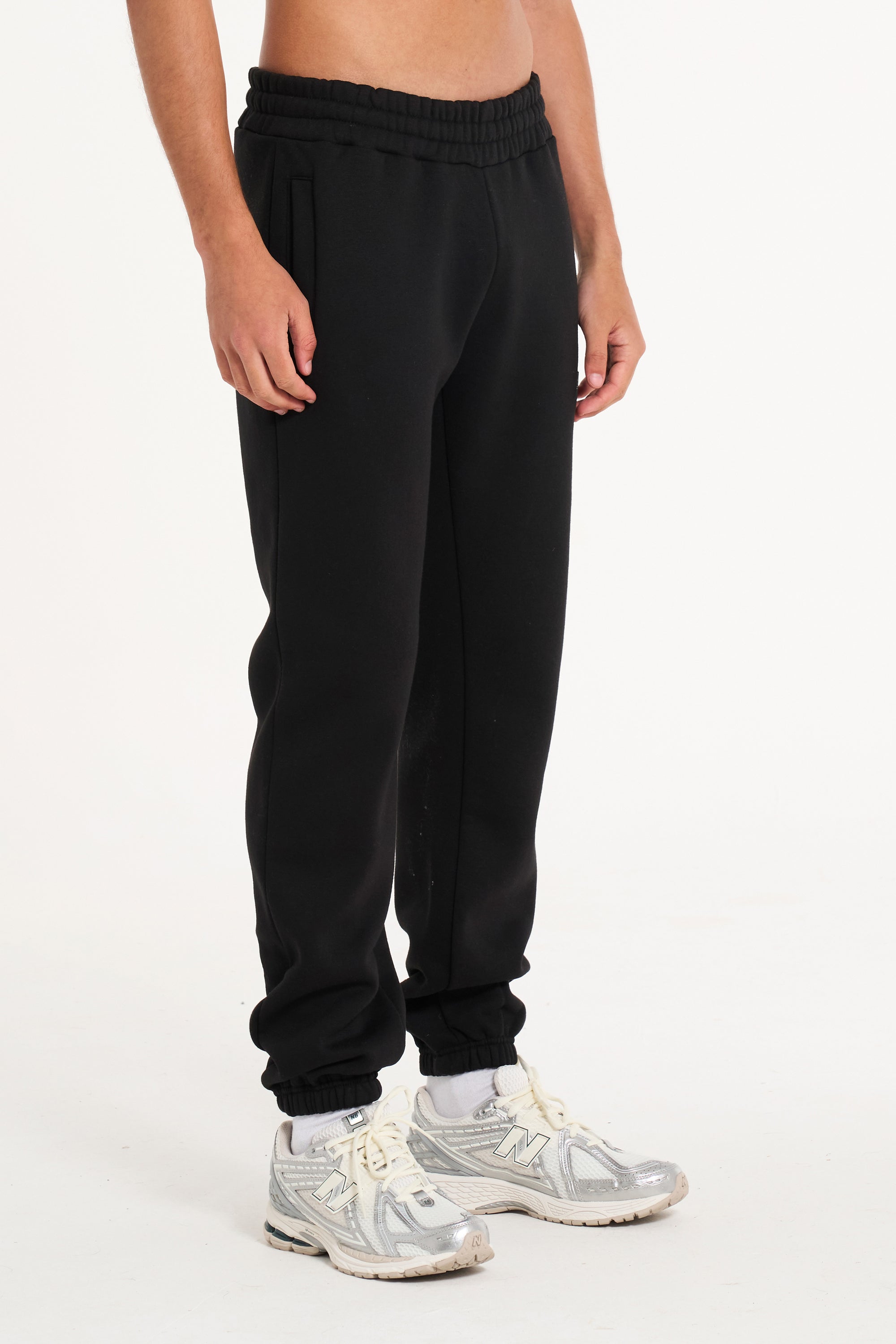 Close up side shot of plain black tracksuit bottoms in black