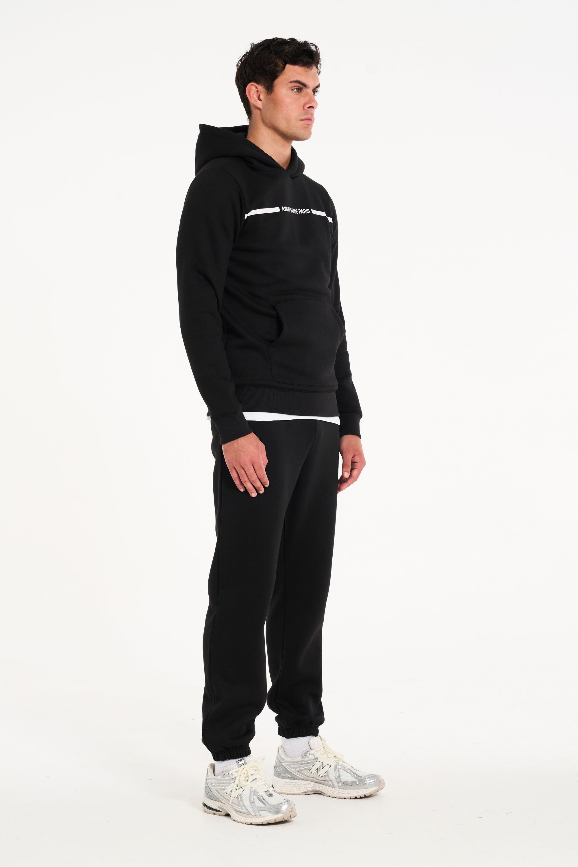 Model facing sidewards wearing men's full tracksuit