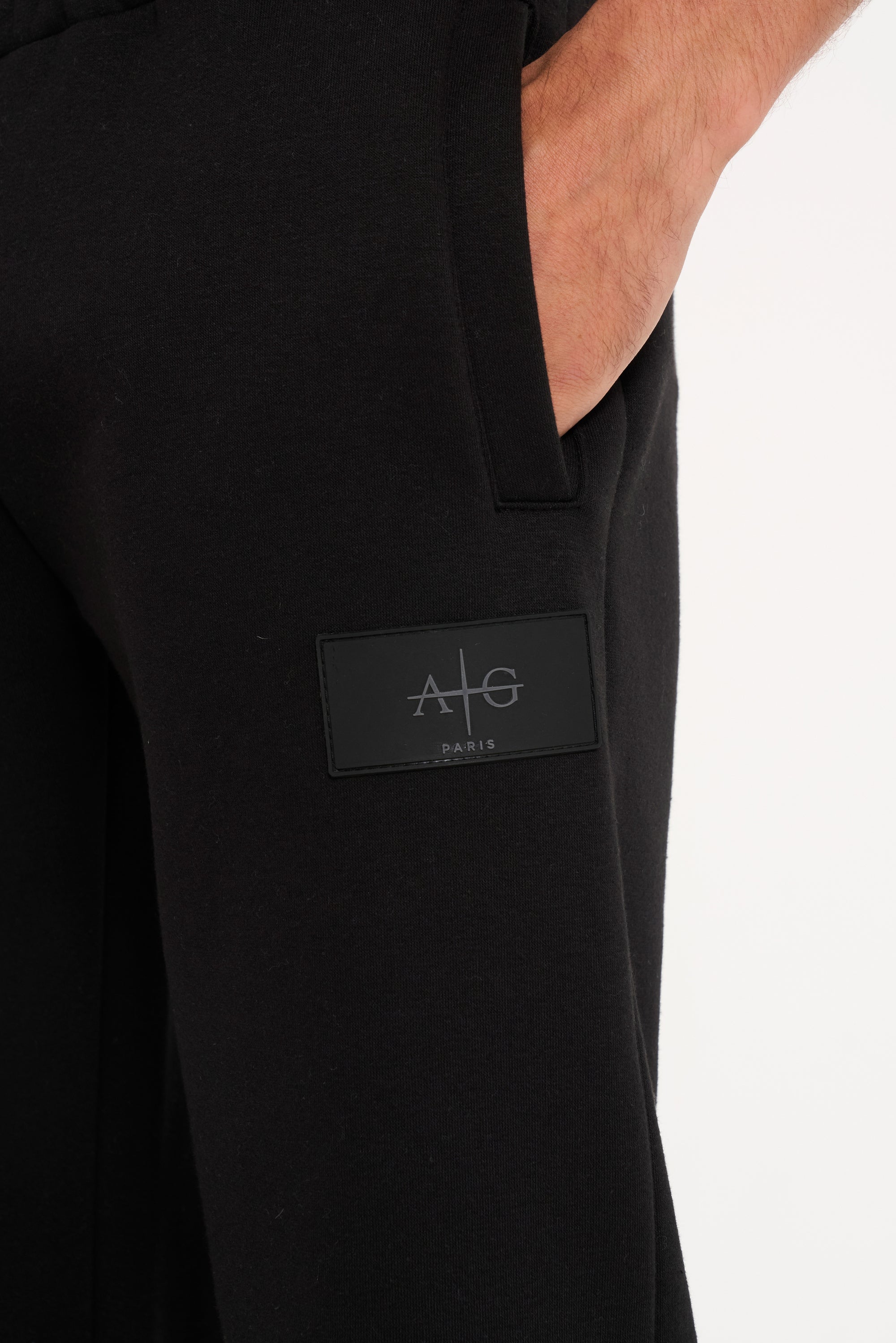 Close up shot of Avant Garde logo on black tracksuit bottoms