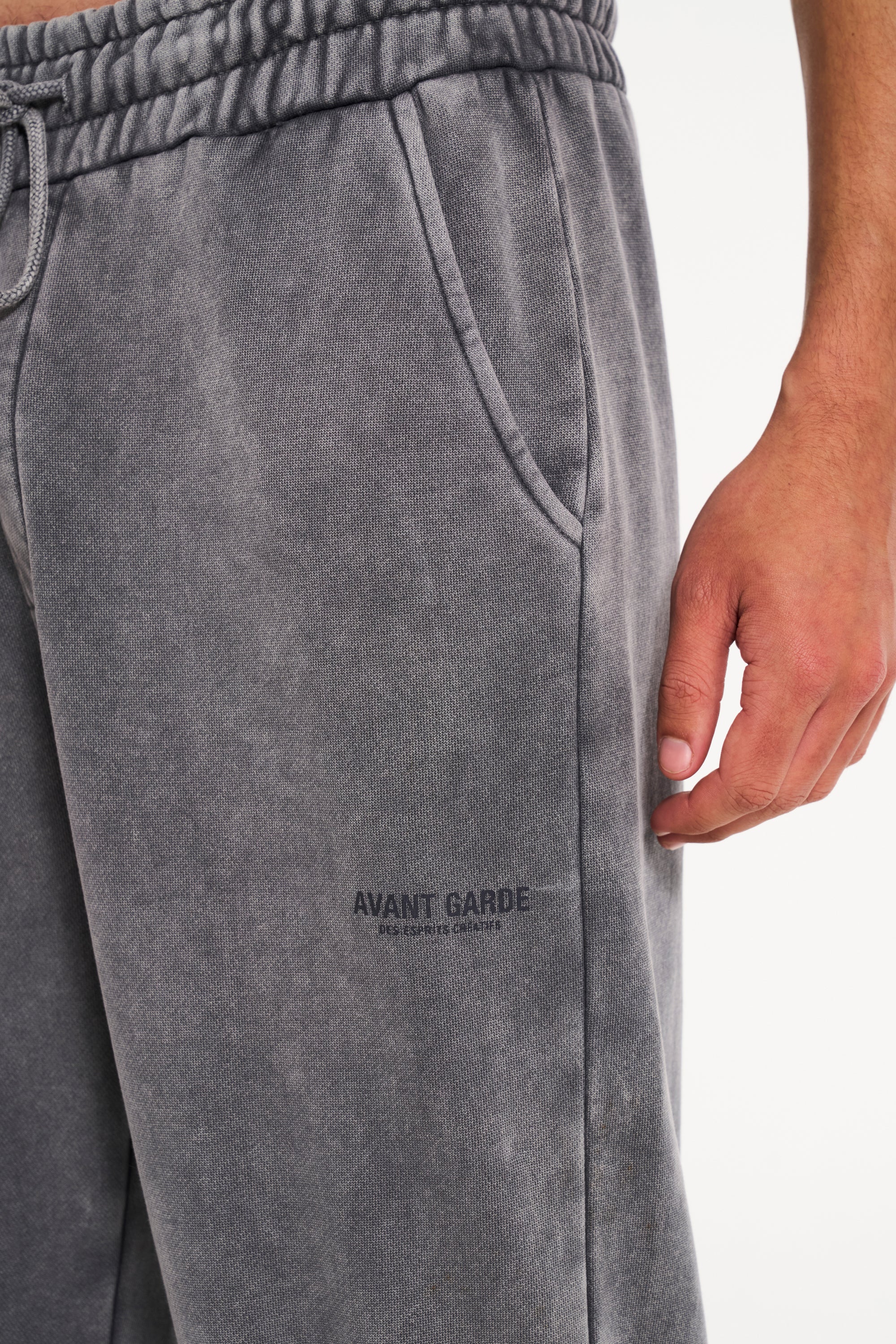 Steel tracksuit bottoms with close up shot of Avant Garde logo