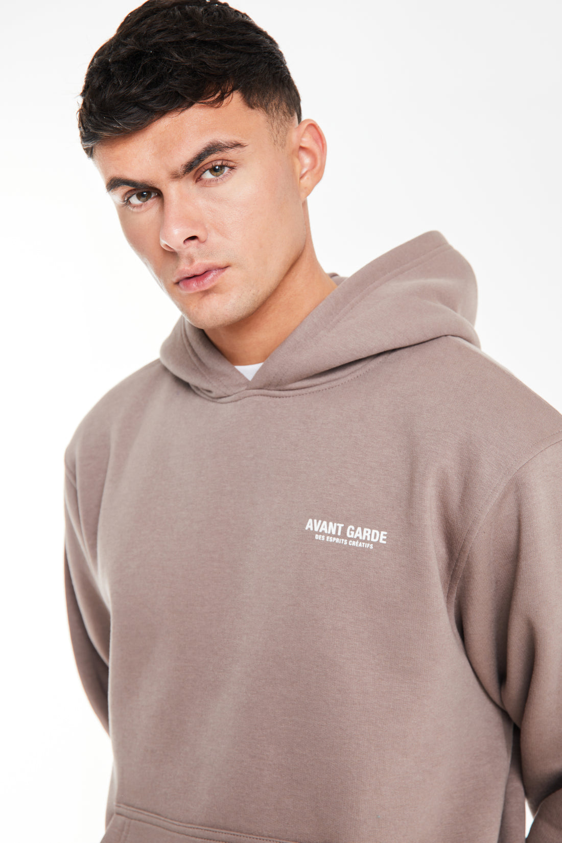 close up of light brown hoodie with a logo on the chest