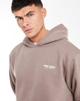 close up of light brown hoodie with a logo on the chest