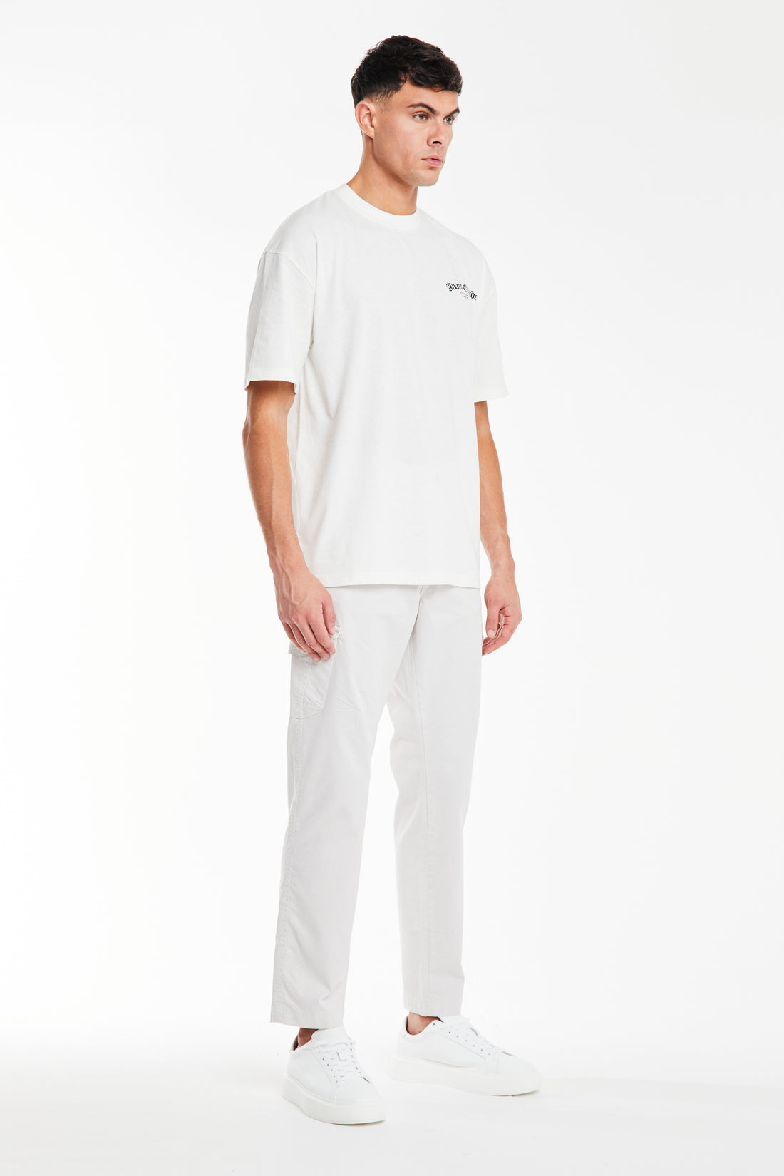 Off-white t shirt styled with pants and trainers