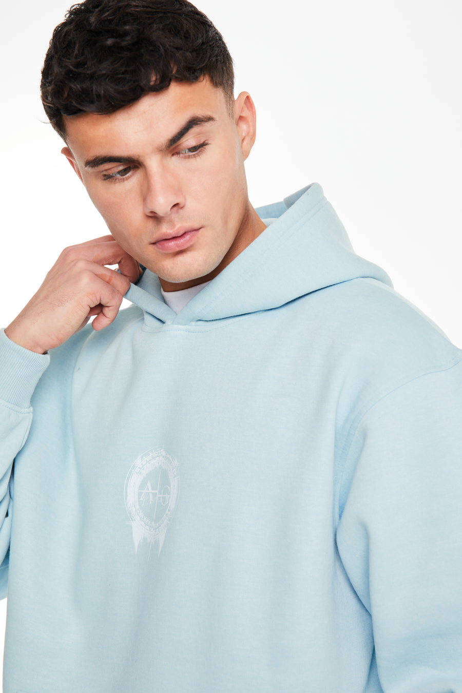 Close up of mens coord set hoodie in baby blue with logo on chest