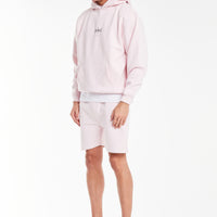 Model wearing a men's coord set in light pink
