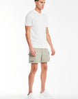 side profile of sage green men's utility shorts styled with a polo