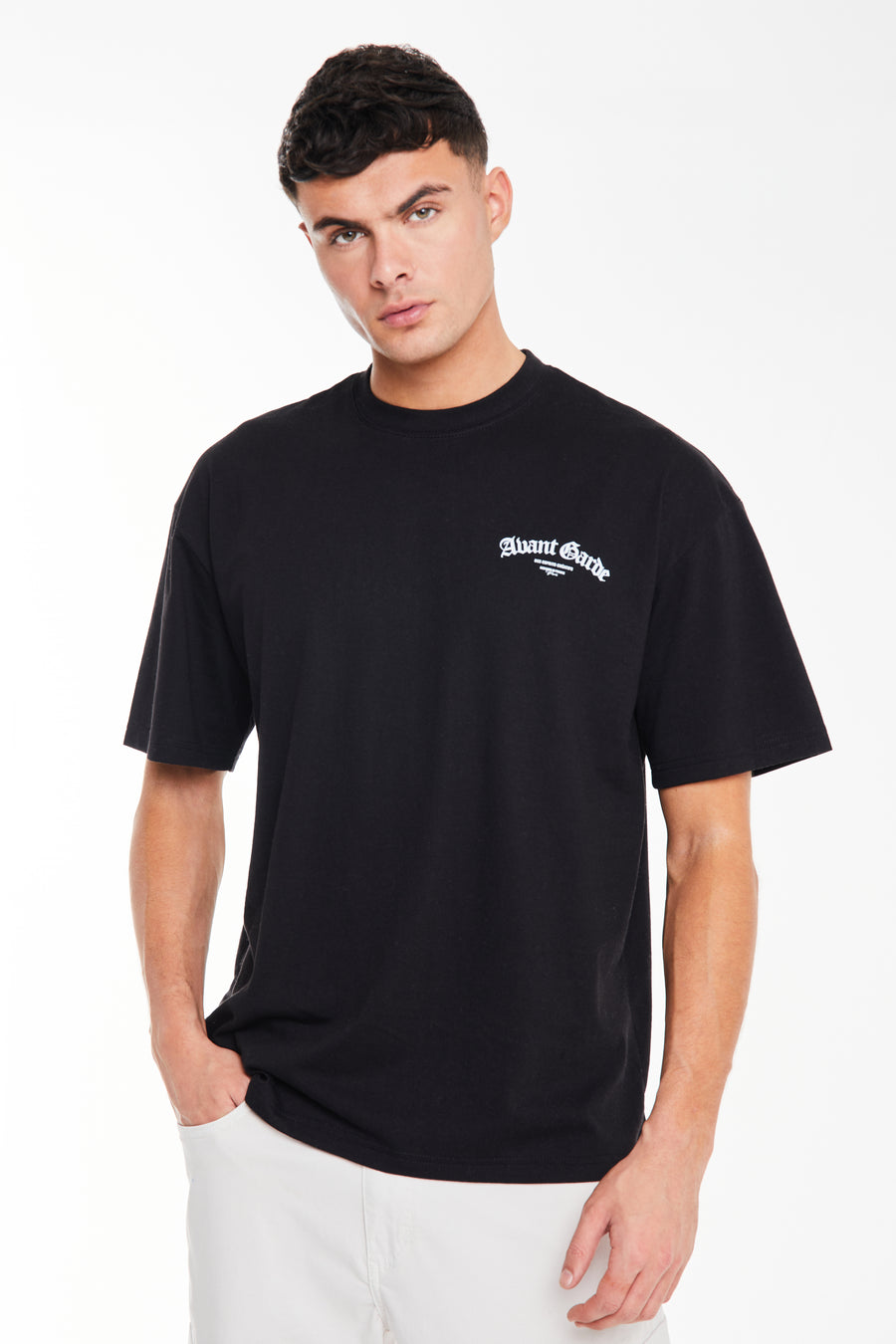 model wearing black t-shirt for men with white 'Avant Garde' logo